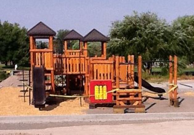 A large wooden playground is seen at a park